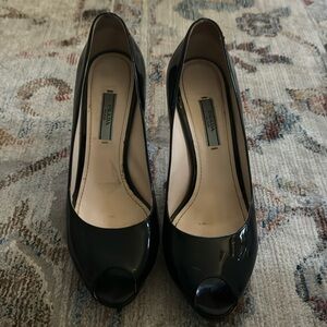 Prada black patent leather open toed heels.
Size 38.5